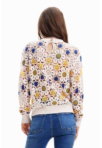 Maglione all'uncinetto in un morbido rosa, caratterizzato da motivi floreali con accenti blu, gialli e verdi. Dettaglio a chiave sulla schiena e orlo a coste.