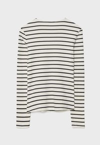 Langærmet top i cremefarvet bomuld med sorte vandrette striber. Har rund halsudskæring og en afslappet pasform med en lige kant.