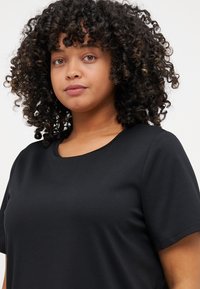 Black short-sleeve T-shirt made from soft fabric with a round neckline. Smooth texture, simple design without patterns or accents.