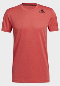 Rød atletisk t-shirt med korte ærmer lavet af letvægtsstof, med et diskret hexagonalt mønster og Adidas-logo i sort på brystet.