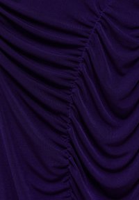 Lila tyg med samlad textur, med framträdande draperingar och mjuk, slät textur. Designad i ett flödande, vågigt mönster.