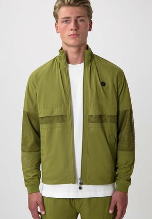 Olijfgroen herenjack met gaasaccenten, voorzien van een hoge kraag, een ritssluiting aan de voorkant en een logo patch op de linkerborst.