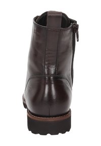 Bottine en cuir marron avec une finition texturée, fermeture éclair sur le côté et une semelle robuste. Coutures renforcées et languette à l'arrière.
