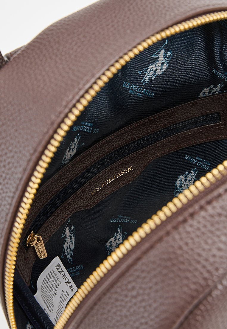 Braunes strukturiertes Innenfutter der Handtasche mit goldener Reißverschluss, versehen mit einem schwarzen Gewebeinnenfutter, das mit einem subtilen Muster des U.S. Polo Assn. Logos geschmückt ist.