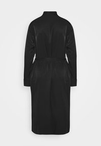 Robe longue satin noir à manches longues avec un col, une taille à nouer et des plis dans le dos, présentant des poignets boutonnés et une texture lisse et brillante.