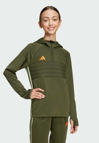 Green athletic hoodie with a zippered front, textured yoke, and orange logo. Smooth fabric and fitted design, paired with matching pants.