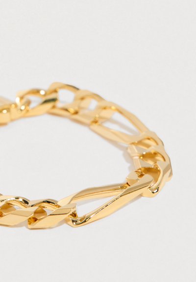 Pulsera de cadena dorada brillante con grandes eslabones planos entrelazados sobre un fondo blanco liso.