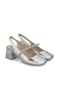 Scarpe slingback metallizzate argento con punta quadrata, tacco basso a blocco e una fascia decorativa di cristalli sul collo del piede. Texture liscia.