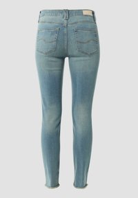 Light blue denim skinny jeans with a mid-rise waist, two back pockets, subtle whiskering, and frayed hems at the ankle.