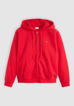 Felpa rossa con zip realizzata in morbido materiale felpato. Presenta un cappuccio con lacci, tasche frontali e un piccolo logo sul lato sinistro del petto.
