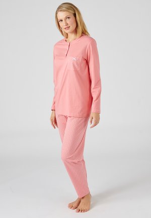 Haut de pyjama rose à manches longues avec une petite poche à motifs de pois, associé à un pantalon rose à pois. Tissu en coton doux, design à coupe décontractée.