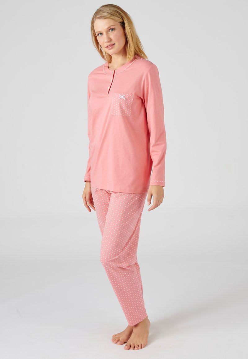 Haut de pyjama rose à manches longues avec une petite poche à motifs de pois, associé à un pantalon rose à pois. Tissu en coton doux, design à coupe décontractée.