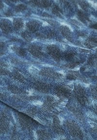 Sciarpa in cashmere con una miscela di tonalità di blu scuro e chiaro, dalla superficie morbida e texture, con bordi frangiati che mostrano un motivo marmorizzato.