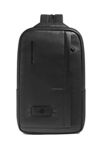 Zwarte leren rugzak met een gestructureerde afwerking, een ritsluiting en een slank profiel. Opvallende merkdetails en minimalistische designelementen.