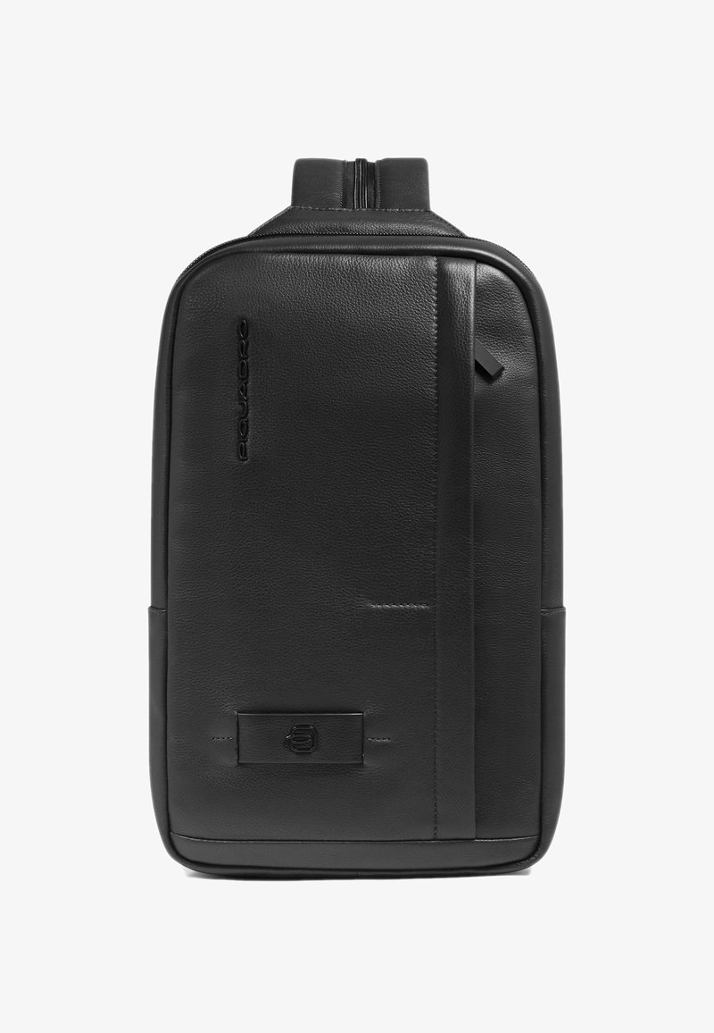 Zwarte leren rugzak met een gestructureerde afwerking, een ritsluiting en een slank profiel. Opvallende merkdetails en minimalistische designelementen.