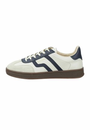 Weißer Sneaker mit niedrigem Profil, dunkelblauen Streifen, beiger Wildleder-Zehenkappe, brauner strukturierter Sohle und weißen Schnürsenkeln, Seitenansicht.