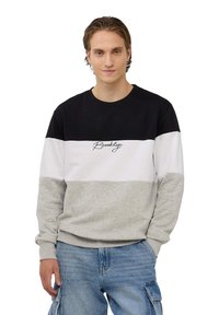 Bluza z bawełny, w kolorowe bloki w odcieniach czerni, bieli i szarości, z napisem "Brooklyn" na klatce piersiowej. Okrągły dekolt.