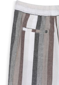 Vertikal gestreifter Stoff in Braun, Weiß, Grau und Schwarz, der eine Eingrifftasche und Details eines elastischen Bundes an den Hosen zeigt.