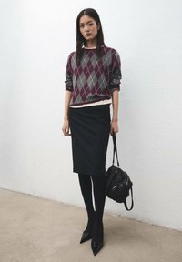 Pulover cu model argyle în burgund și gri, fustă creion neagră, ciorapi negri și botine negre cu vârf ascuțit. Geantă neagră cu mâner scurt.