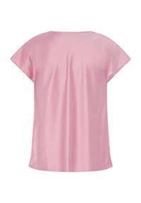 Blouse rose pâle à manches courtes avec une coupe ample, un col rond et un tissu lisse, vue de dos.