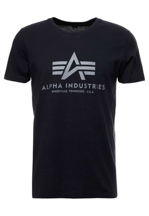 T-shirt in cotone blu navy con maniche corte, caratterizzato da un logo grafico argentato e dal testo "ALPHA INDUSTRIES" centrato nella parte anteriore.