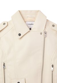 Giacca in similpelle color crema con collo strutturato, hardware argentato, cerniere oblique ed epaulettes sulle spalle. Etichetta della taglia visibile.