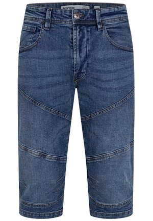Denimshorts i middels blå vask med smal benutforming og diagonale sømdetaljer med kontraststing.