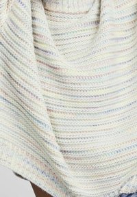 Stickad tröja med en krämvit bas och subtila pastellrandningar. Mjuk textur med ribbad nederkant och varierande stickmönster. Avslappnad design.