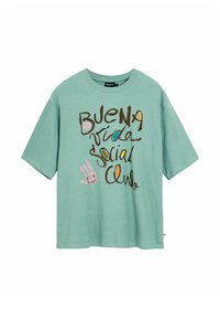 Green cotton t-shirt with short sleeves, featuring brown and colorful text that reads "BUENA vida Social Club," with a hand illustration.