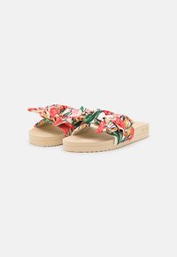 Pantofle s květinovým vzorem a uzlovým textilním svrškem v růžové, červené a zelené barvě, umístěné na béžové gumové podrážce s texturovaným profilováním.