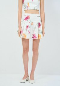 Weißer Rock mit floralem Druck und Rüschen, verziert mit rosa und orangefarbenen Blumen. Hergestellt aus leichtem Stoff, mit einer taillierten Silhouette gestaltet.