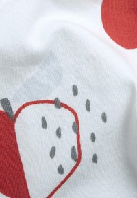 Tela de algodón con un diseño de manzanas rojas y semillas gris oscuro, fondo blanco y textura suave, mostrando un patrón juguetón.