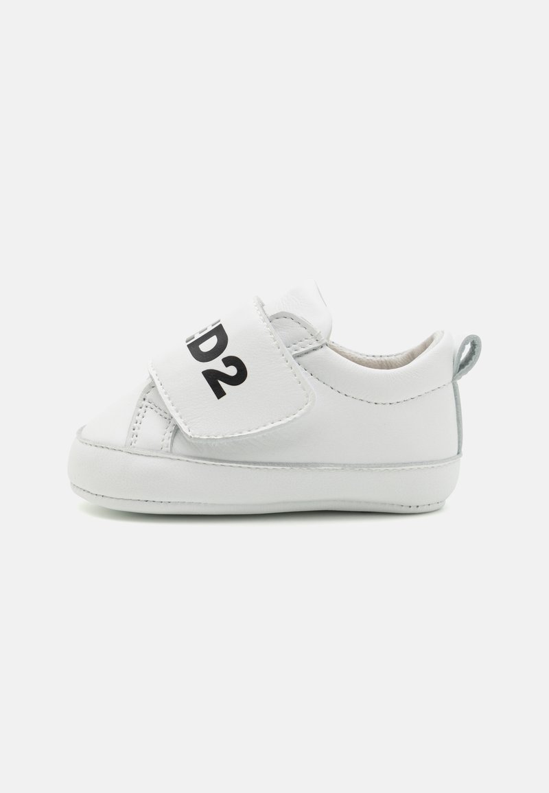 Valkoinen vauvan lenkkari, jossa on pehmeä nahkapäällinen, tarranauha ja harmaat yksityiskohdat kantapäässä, tarranauhan päällä musta teksti "D2".