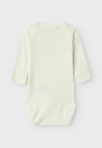 Bodysuit pour bébé de couleur crème clair, à manches longues, avec un col rond et une fermeture à boutons-pression en bas. Tissu en coton doux et lisse.