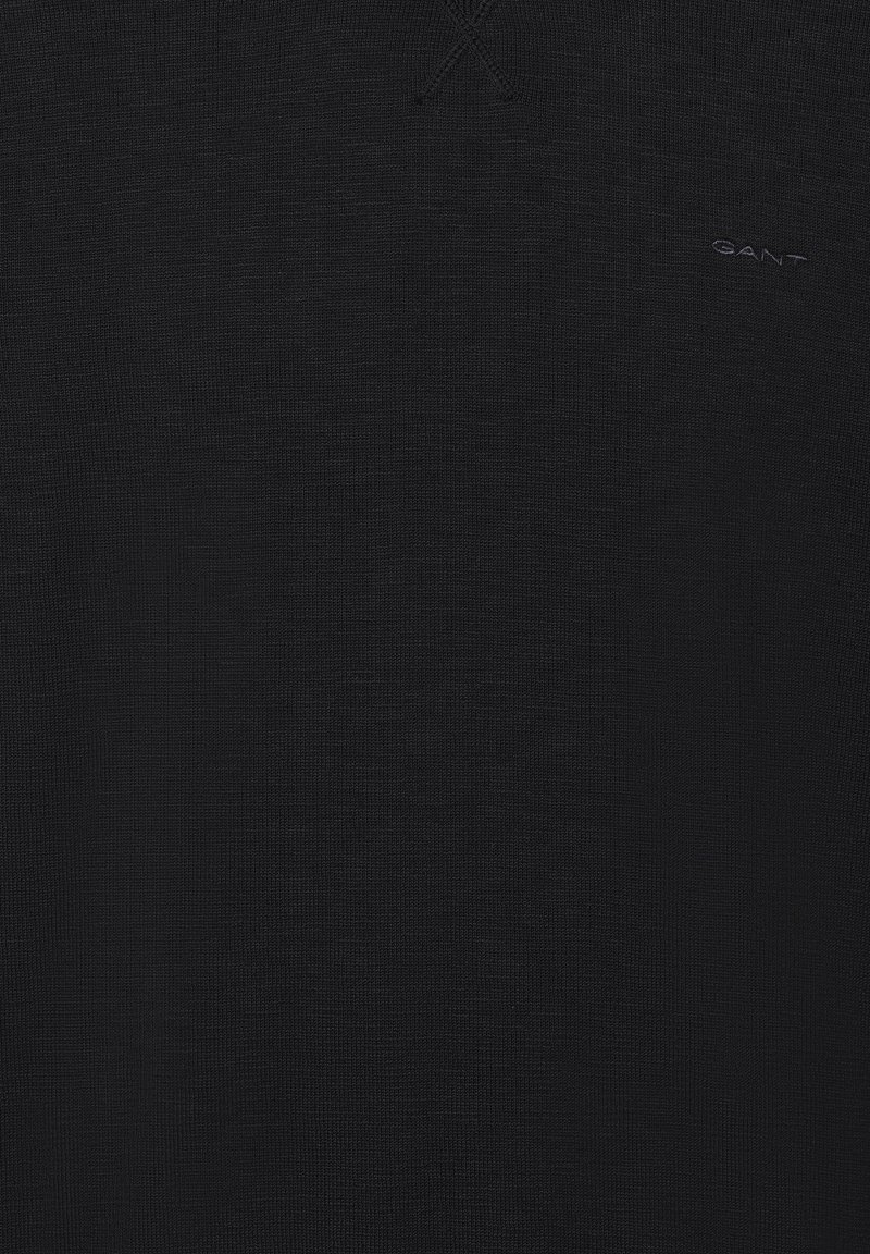 Schwarzer Pullover aus strukturiertem Stoff mit einem dezenten Logo in der unteren rechten Ecke. Verfügt über ein Kreuzstichdesign am Halsausschnitt.