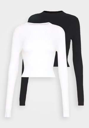 Two long-sleeve ribbed tops: one in white and one in black, featuring round necklines and a cropped fit. Texture is smooth and stretchy.