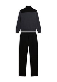 Chándal gris y negro, con cuello alto y panel de contraste en los hombros de la chaqueta, y pantalones con cintura elástica, confeccionado en tela suave.