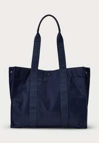 Námornícky modrá taška na rameno vyrobená z nylonu s textúrovanými, embosovanými popruhmi a elegantným, minimalistickým dizajnom. Obsahuje uzáver na cvoky a bočné vrecká.