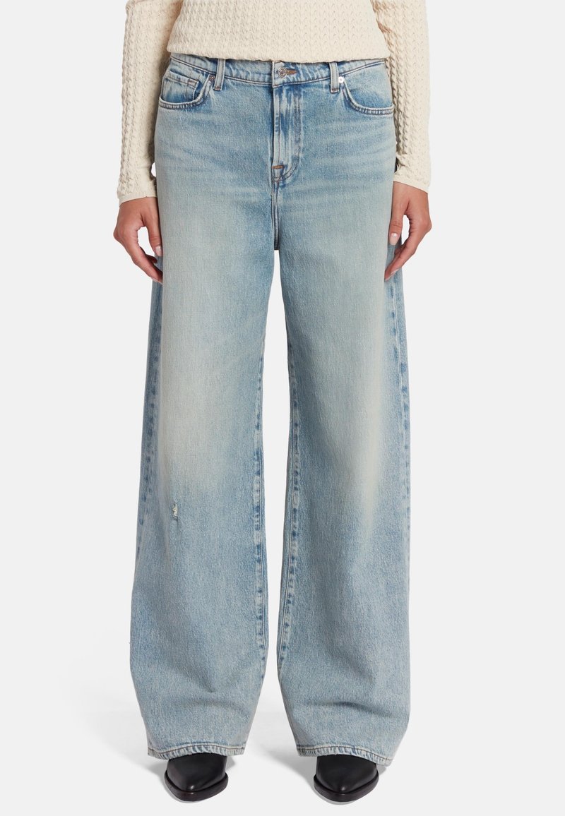 Lichtblauwe, wijde jeans met een vervaagde afwerking, voorzien van vijf zakken en metalen hardware accenten. Ontspannen pasvorm met een middelhoge tailleband.