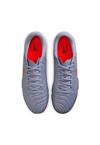 Nike Tiempo shoes with a light gray synthetic upper, red accents, textured design, and black rubber soles. Features standard lacing system.