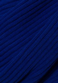 Rippstoff in einem tiefen Blau mit einer strukturierten Oberfläche. Das Material erscheint weich und weist gleichmäßig verteilte vertikale Linien auf.