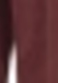 Tessuto di poliestere bordeaux con una superficie liscia, caratterizzato da una leggera lucentezza. Il design include una caduta lieve e dettagli minimalisti.