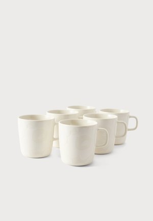 Sześć prostych białych ceramicznych kubków z uchwytami ułożonych w dwóch rzędach na jasnym tle.