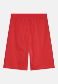 Rote Baumwoll-Shorts mit entspannter Passform. Mit einem elastischen Bund und glatter Textur, reichen sie bis knapp über das Knie.