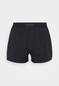Black men's boxer shorts with elastic waistband featuring Calvin Klein logo, front fly, and smooth fabric construction.