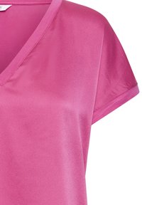 Blouse rose vif à manches courtes avec col en V, tissu lisse et coutures simples sur les manches et le col.