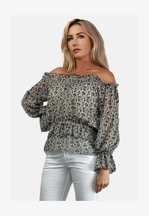 Bluse mit schulterfreiem Design in hellblumigem Druck, durchscheinendem Stoff mit Rüschendetails und elastischem Bund. Kombiniert mit weißen, eng anliegenden Hosen.