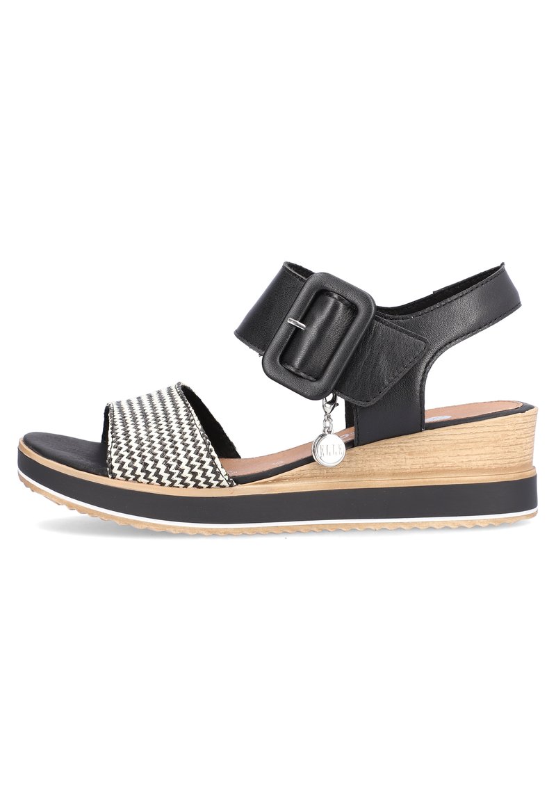Sandal i sort-hvidt mønster med en bred rem, spændeaccent og en let vristso. Teksturering som trælook og sort bund.
