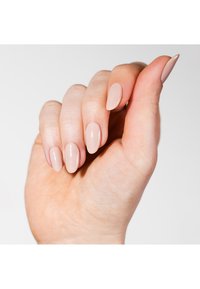 Nagellak in een zachte beige kleur, soepel aangebracht op lange, amandelvormige nagels. De hand heeft een lichte huidskleur en is elegant gepositioneerd.