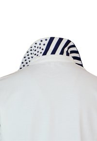 Bílá polokošile s límečkem, který má vzor hvězd a pruhů v námořnické modři a bílé. Límec má šikmý design s grafickými detaily.